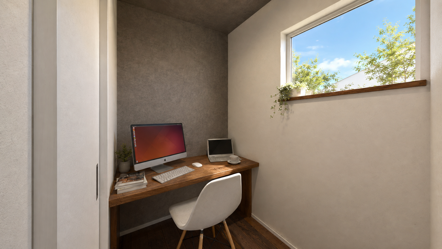 Cozy home office with wooden desk, Apple iMac, keyboard, mouse, a small plant, and a laptop on the corner, under a textured gray wall, near a window with greenery outside.
