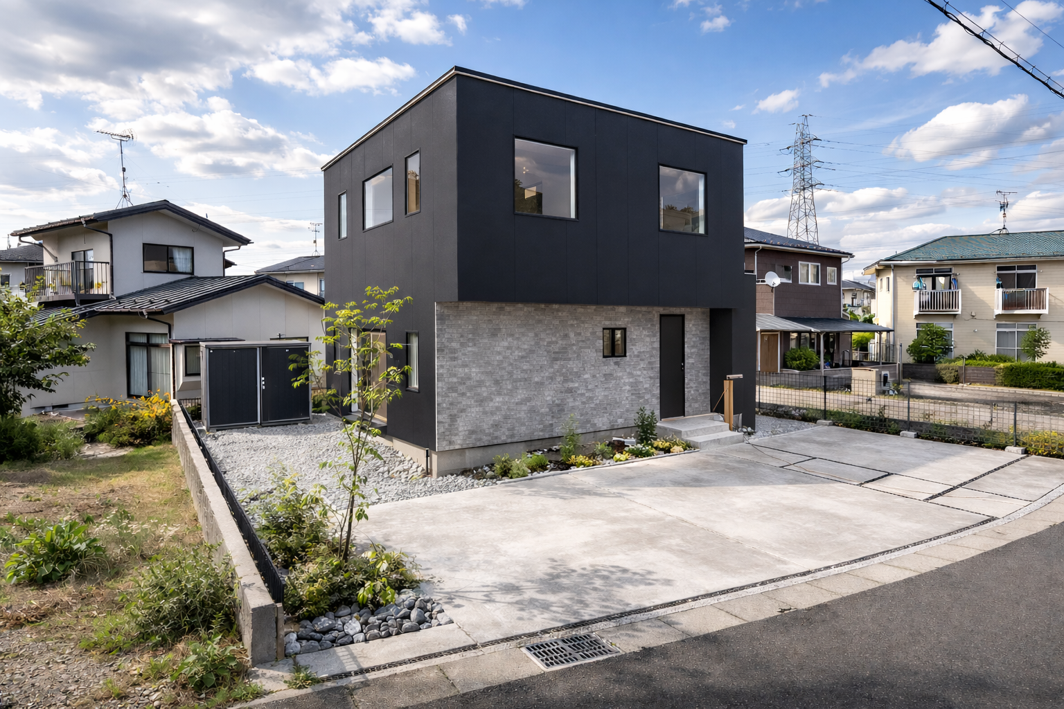 Modern two‑story black and gray house with large windows, gravel yard, and a concrete driveway in a suburban street.