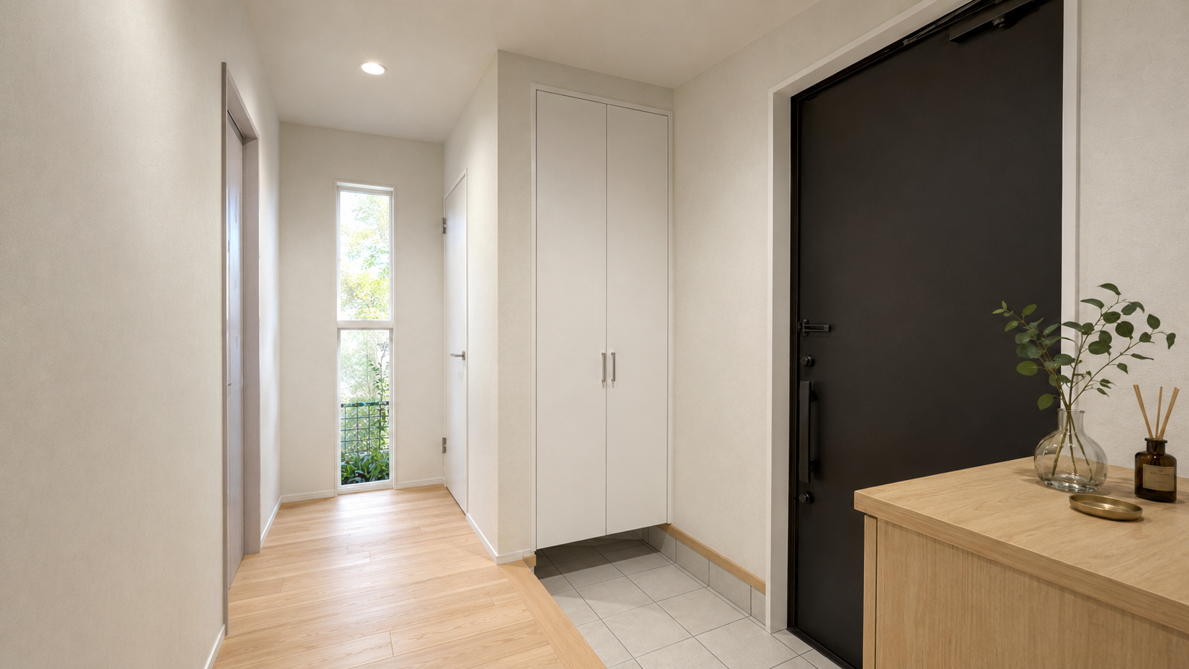 Bright entry hallway with light wood flooring, white storage cabinet, and a large black front door; a wooden console with a vase and reed diffuser on the right.